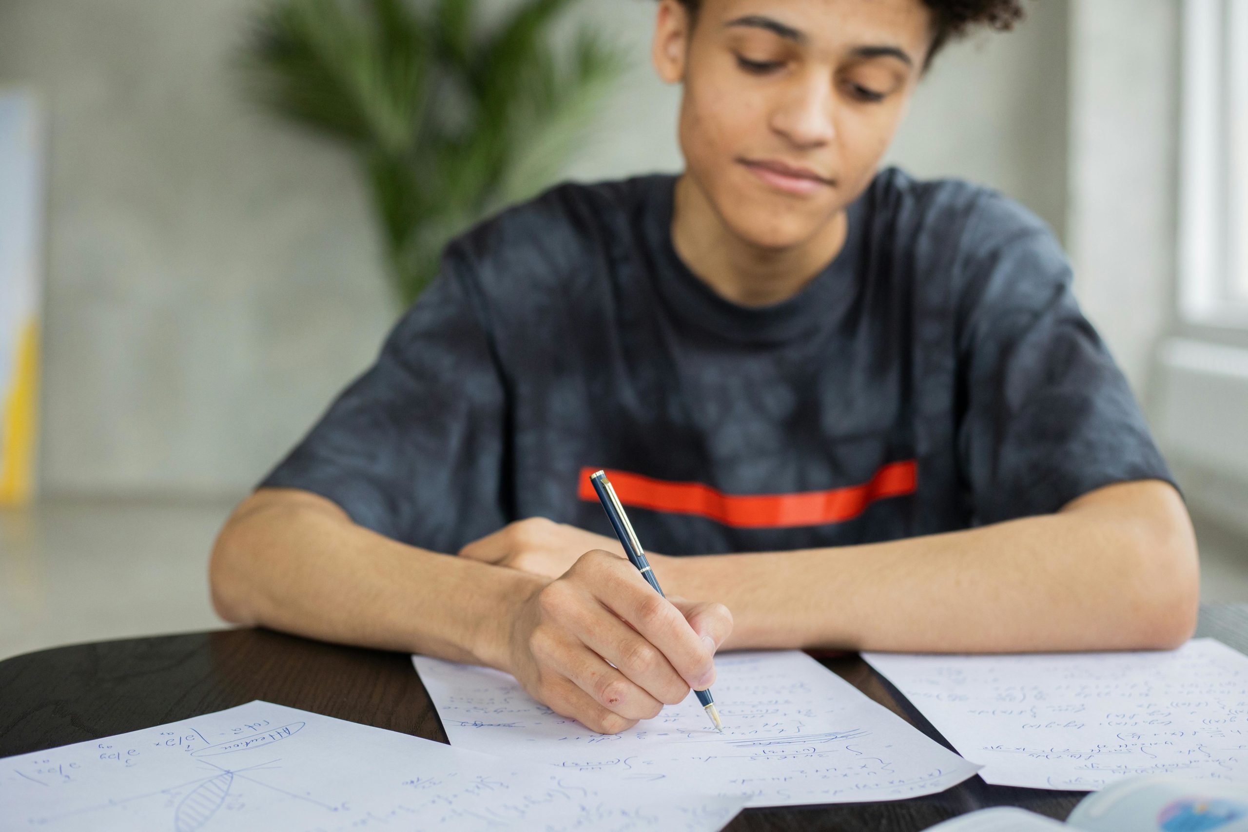 pexels-gabby-k-6238022 boy writing on white paper